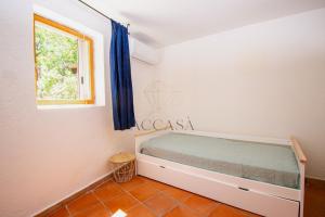 een slaapkamer met een bed en een raam bij Villa Mare è Macchia Accasà in Bonifacio