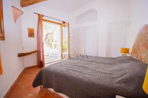 een slaapkamer met een bed en een groot raam bij Villa Mare è Macchia Accasà in Bonifacio +6 foto's