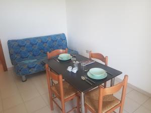 a dining room with a table and chairs and a couch at Bilocali Baia Verde in Baia Verde