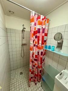 a shower with a colorful shower curtain in a bathroom at Kustverhuur, Park Schoneveld Duinroos 131 in Breskens +9 photos