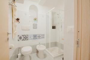 a white bathroom with a toilet and a shower at Palazzo Pezzolla Apartments in Monopoli +58 photos