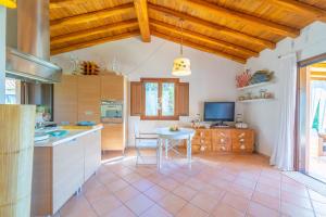 Punta MolaraVilla Molara Home - By Searly的厨房配有桌子和电视。