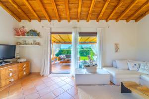 Punta MolaraVilla Molara Home - By Searly的客厅里有一张沙发和一台电视