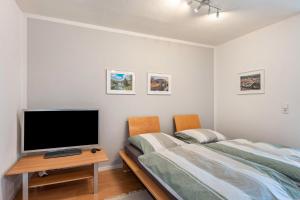a bedroom with two beds and a television on a table at Kocher und Jagst in Michelbach an der Bilz