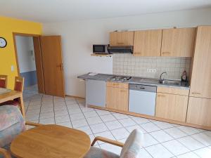 a kitchen with wooden cabinets and a table in a room at Gasthaus-Pension-Ferienwohnung Zum Engel in Waldbrunn