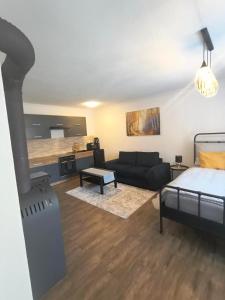 a bedroom with a bed and a living room with a couch at apartmán 1kk Zlámanka in Kroměříž