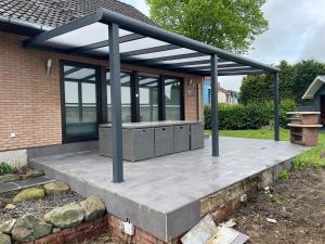 eine Pergola auf einer Terrasse außerhalb eines Hauses in der Unterkunft Blauer Stein 07 Haus in Pulheim