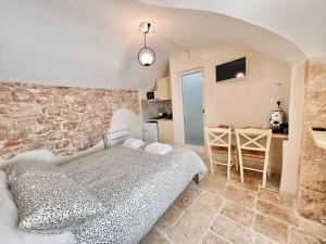 a bedroom with a bed and a stone wall at Lo Juso in Putignano