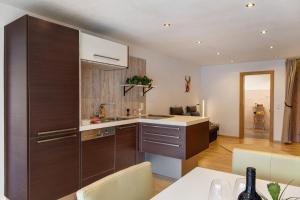 a kitchen with brown cabinets and a dining room at Apart Gabl in Fliess +7 photos
