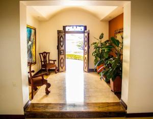 a hallway with an open door with a chair and plants at Hotel Boutique Villa Casuarinas in Cali