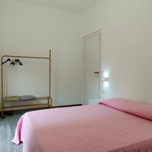 a bedroom with a pink bed and a mirror at Life Home in Scilla