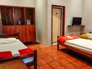 安达拉伊Pousada e Hostel Andarai的一间有两张床和一台电视的房间