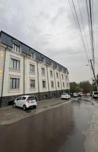 a large white building with cars parked in front of it at Samanid hotel in Salor Bekati