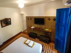 安达拉伊Pousada e Hostel Andarai的一间设有床铺和墙上电视的房间
