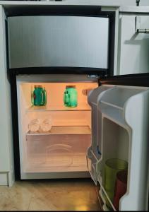 een open koelkast met daarin twee groene potten bij Lofts #9 & #6 Surf EcoVilla Playa El Sunzal in El Sunzal