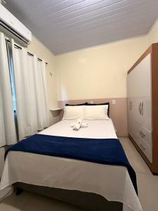 a bedroom with a large bed with a blue blanket at Residencial Davisis - Parada do Jalapão in Palmas