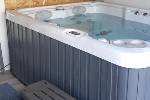a jacuzzi tub in a room with a chair at Bali Hi Cliff Cottage-Sleeps 2-Hot Tub-5MinBeach in Sheerness +10 photos