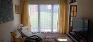 a living room with a chair and a large window at Bali Hi Cliff Cottage-Sleeps 2-Hot Tub-5MinBeach in Sheerness