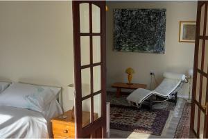 a bedroom with a bed and a chair in a room at Bali Hi Cliff Cottage-Sleeps 2-Hot Tub-5MinBeach in Sheerness