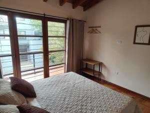 Ubicación y todo para tu desayuno في ميندوزا: غرفة نوم بها سرير ونافذة كبيرة