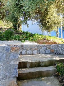 a stone retaining wall with stairs in front of a building at Stefanos Garden2 in Arménoi