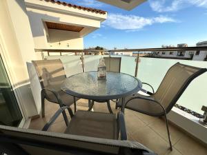 a table and chairs on a balcony with a bottle on it at Casa Sea Breeze in Larnaca