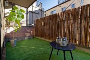 a small patio with a table and a fence at Palette house Spacious 56 sqm Tokyo Apartment near Station in Tokyo