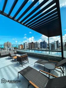 un patio all'ultimo piano con tavoli e sedie in un edificio di Uni Tamari Intermares - LikeHome Hospedagens a Cabedelo