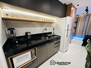 una cucina con frigorifero bianco e forno a microonde di Uni Tamari Intermares - LikeHome Hospedagens a Cabedelo