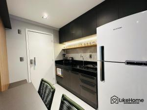 una cucina con frigorifero, tavolo e sedie di Uni Tamari Intermares - LikeHome Hospedagens a Cabedelo Altre 9 foto