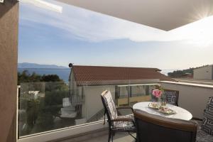 a balcony with a table and chairs and a view of the ocean at Apartman MORE Živogošće in Živogošće
