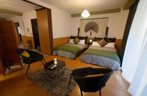a bedroom with two beds and a table and chairs at Palette house Spacious 56 sqm Tokyo Apartment near Station in Tokyo
