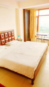 a large bed in a room with a large window at Shri Radhe BNB in Shimla