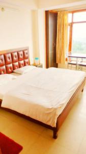 a large bed in a bedroom with a large window at Shri Radhe BNB in Shimla