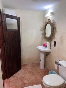 une salle de bain avec des toilettes, un lavabo et une porte dans l'établissement kasbah Dar Bahnini, à Skoura 37 autres photos