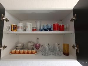 a cupboard filled with lots of glasses and vases at Apartament Flora in Văleni