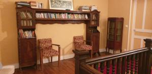 a living room with two chairs and a book shelf at grande maison de famille prés d'Hossegor in Bénesse-Maremne +17 photos