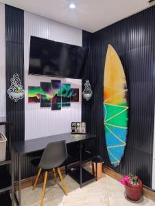 un muro nero con una tavola da surf in una stanza di PraiAna Loft Arraial do Cabo ad Arraial do Cabo