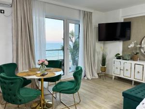 a living room with a table and chairs and a large window at Heaven Infinity Sunrise Pool & SPA in Mamaia Sat/Năvodari