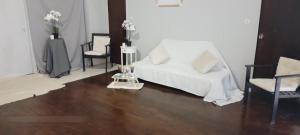 a living room with a white couch and two chairs at Spacious seaside house in Nea Makri in Nea Makri
