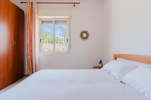 a bedroom with a white bed and a window at Villino Occhi di Mare - Salento Selection in Casalabate +15 photos