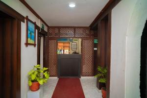 un corridoio di un edificio con porta e piante di Hotel Juju a Pokhara