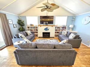 un salon avec deux canapés et une cheminée dans l'établissement Oceanfront Beach House - Pool, Private Beach Access, Sleeps 12, à Cocoa Beach