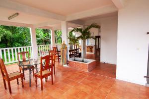 a living room with a fireplace and a table and chairs at Villa Kamy'el in Saint-Joseph