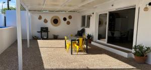 a patio with yellow chairs and a table on a house at Casa Rural Macondo in Trujillanos