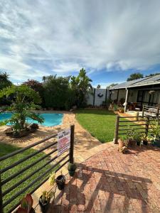 a sign in front of a house with a pool at DuyneGuestHouse in Cape Town