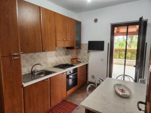 a kitchen with wooden cabinets and a sink and a table at Residenza Giscor in Gasponi