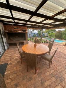 a wooden table and chairs on a patio at DuyneGuestHouse in Cape Town