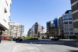 an empty street in a city with tall buildings at Penthouse bij Leopoldpark in Ostend