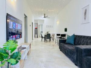 a living room with a black couch and a table at 7Pax BM大山脚 Singlestorey Alma 8minute to Aeon mall in Bukit Mertajam